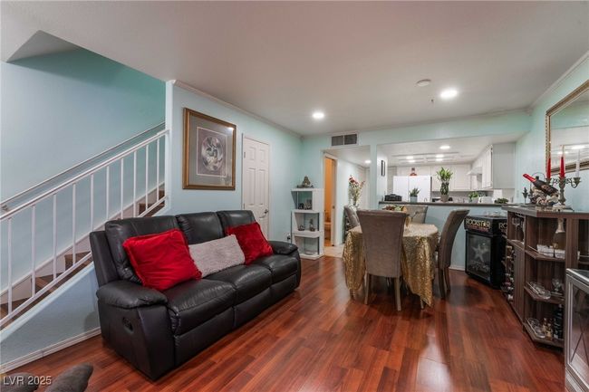 Living area featuring recessed lighting, dark wood-style flooring, crown molding, stairs, and visible vents | Image 9