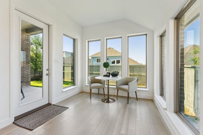 Sunroom featuring wood finished floors, vaulted ceiling, and baseboards | Image 12