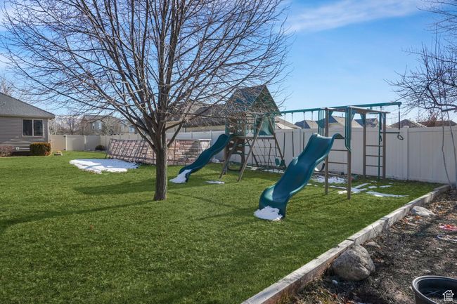 View of jungle gym with a fenced backyard and a lawn | Image 31