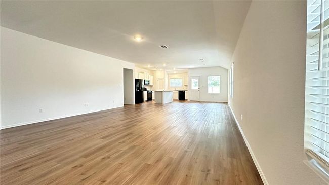 Unfurnished living room featuring baseboards, wood finished floors, and visible vents | Image 18