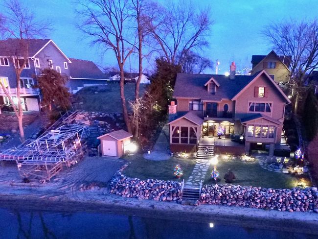 Evening view of the property after the dock came in for the year. Note the extensive landscaping completed on the vacant lot. Note, you can see on the left side of the house the paver ramp to get up and down. Same can be found on the vacant lot | Image 6