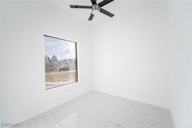 Spare room featuring lofted ceiling and ceiling fan | Image 15