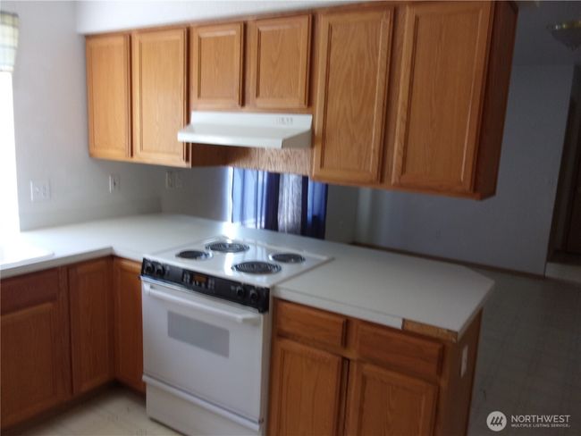 Kitchen has range/oven and oak cabinets. | Image 13