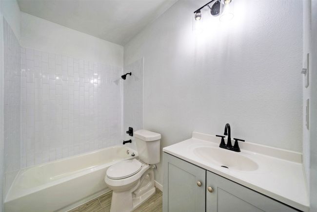 Full bath featuring shower / washtub combination, vanity, and wood finished floors | Image 16
