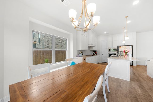 Dining area featuring light wood-type flooring, a chandelier, and recessed lighting | Image 8