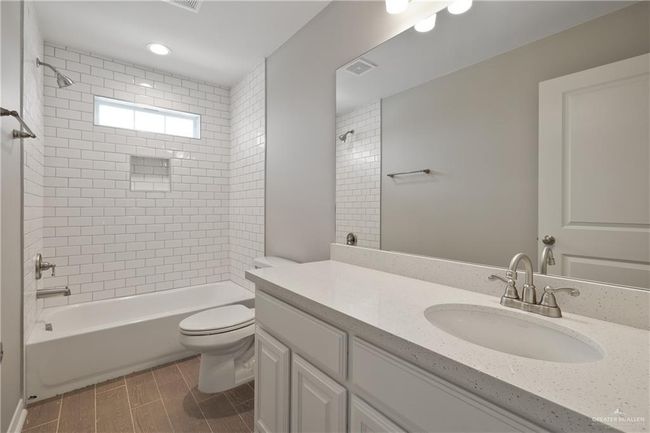 Bathroom featuring vanity, toilet, shower / tub combination, and wood tiled floors | Image 11