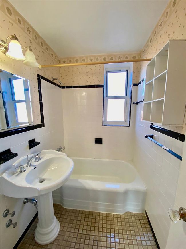 Bathroom with tile walls, wallpapered walls, plenty of natural light, shower / bathtub combination, and tile patterned floors | Image 6