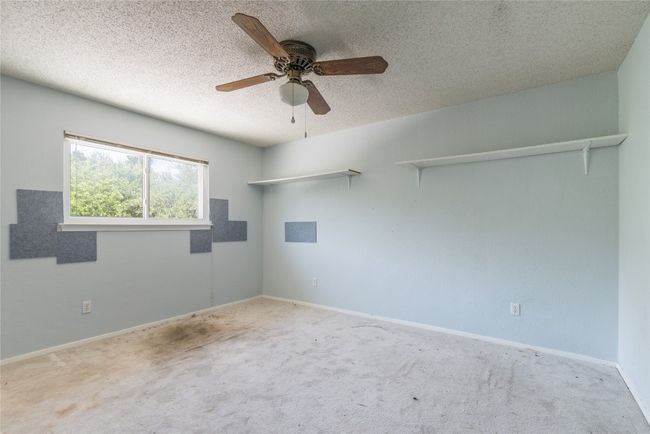 Carpeted spare room featuring ceiling fan, a textured ceiling, and baseboards | Image 18