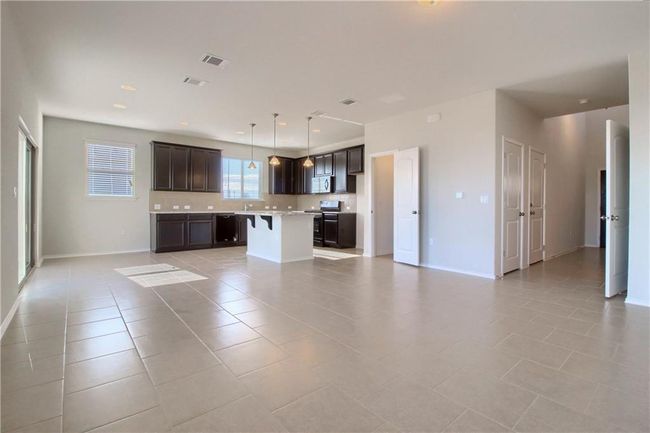 Unfurnished living room featuring light tile patterned floors, baseboards, and a sink | Image 5
