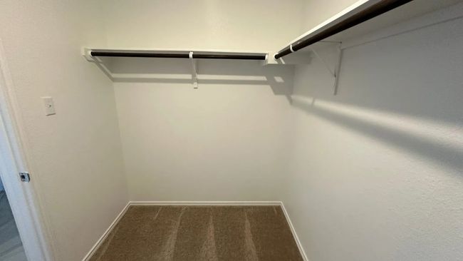 Walk in closet with dark colored carpet | Image 16