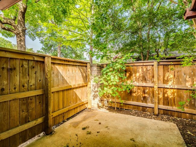 Fenced backyard with a patio | Image 14