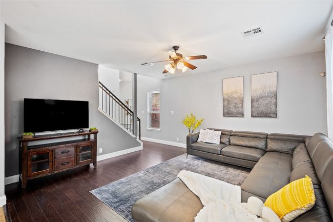 Living room featuring stairs, ceiling fan, and hardwood / wood-style floors | Image 7