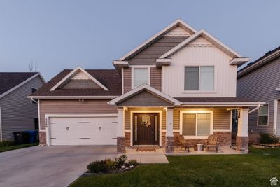 Craftsman house featuring a garage, a front lawn, and covered porch | Image 1