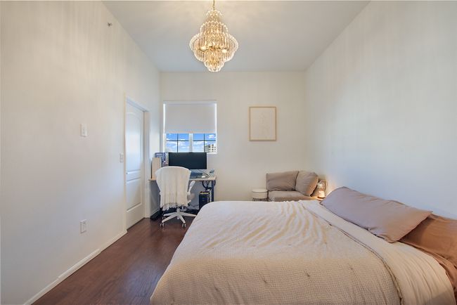 Bedroom with a chandelier, dark wood-style flooring, baseboards, and a desk | Image 14