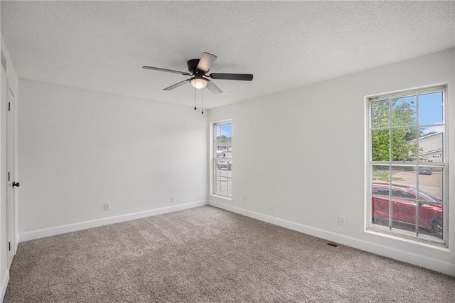 Spare room featuring ceiling fan, carpet flooring, baseboards, and a textured ceiling | Image 11