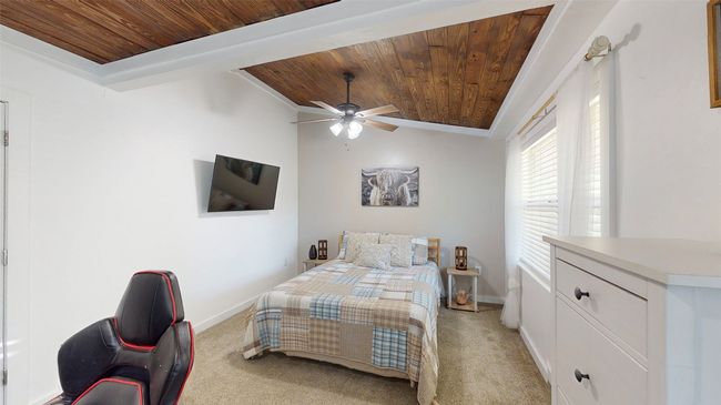 Bedroom with vaulted ceiling, carpet flooring, and a wall mounted AC | Image 17