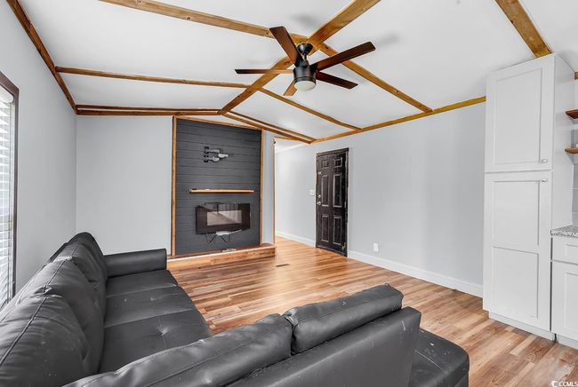 Living room featuring a fireplace, baseboards, a ceiling fan, and light wood-type flooring | Image 19