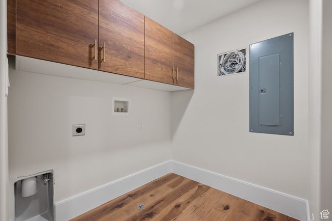 Laundry room with electric panel, cabinet space, hookup for a washing machine, wood finished floors, and hookup for an electric dryer | Image 67
