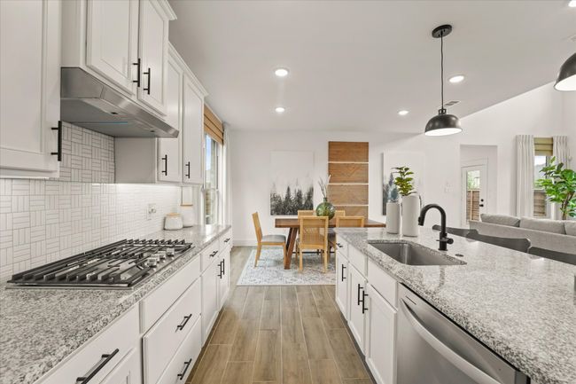 Kitchen featuring appliances with stainless steel finishes, tasteful backsplash, healthy amount of natural light, recessed lighting, and white cabinetry | Image 20