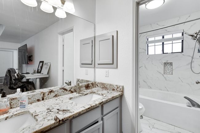 Full bathroom with double vanity, marble finish flooring, and shower combination | Image 21