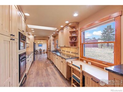 Galley kitchen with ample counter and cabinet space for everything you want to do. A skylight in the kitchen provides additional natural light making the room both airy and cozy at once. | Image 3