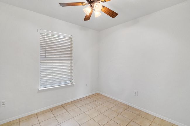 Empty room featuring ceiling fan and light tile patterned floors | Image 16