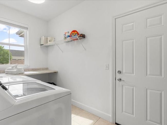 Laundry room featuring independent washer and dryer and light tile patterned flooring | Image 19