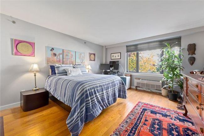 Bedroom with hardwood / wood-style flooring and an AC wall unit | Image 5