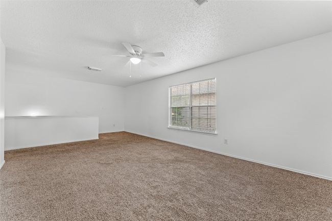 Spare room featuring a ceiling fan, carpet, a textured ceiling, and baseboards | Image 23