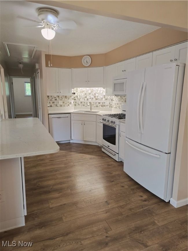 Kitchen featuring refrigerator, dishwasher, stove, white cabinetry, and tasteful backsplash | Image 8
