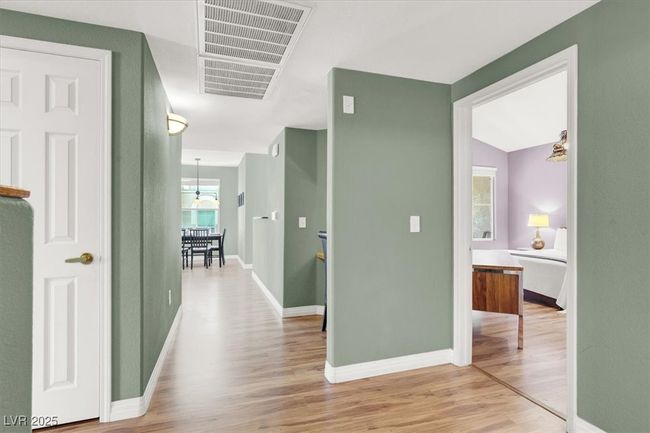 Corridor featuring visible vents, wood like finished floors, and baseboards | Image 5