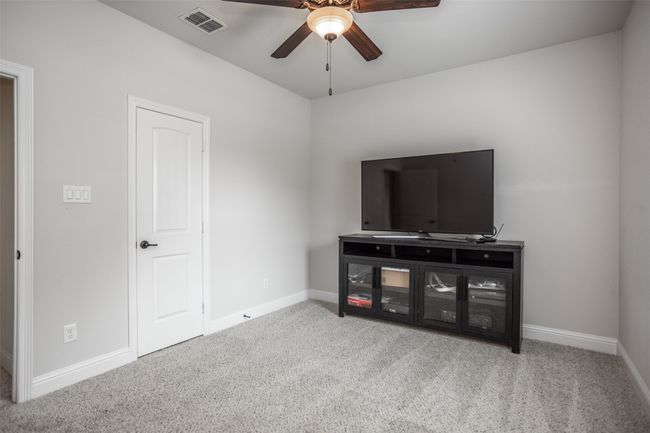 Bedroom with a ceiling fan and carpet floors | Image 36