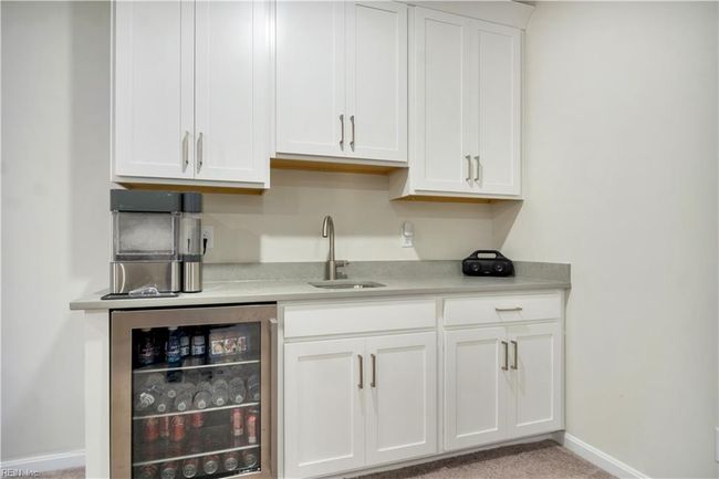 Wet bar with beverage cooler and plenty of cabinet storage. | Image 38