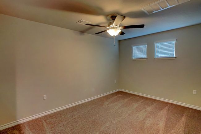 Carpeted empty room featuring baseboards, ceiling fan, and visible vents | Image 15