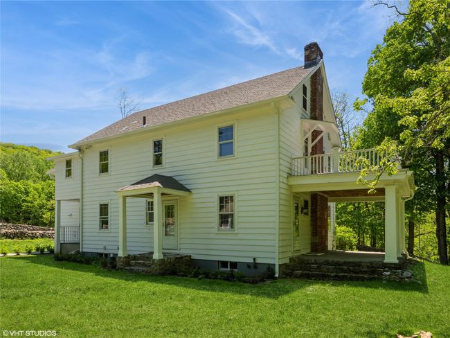 Rear view of house featuring a chimney, a balcony, and a yard | Image 13