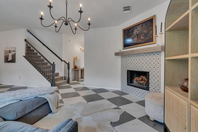 Living room featuring a chandelier, stairs, and a tile fireplace | Image 11