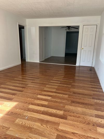 Unfurnished bedroom featuring a textured ceiling and wood-type flooring | Image 2