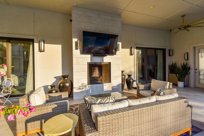 Outdoor living area featuring fireplace is the perfect place to relax and entertain. | Image 44