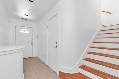 Front door entry way, garage door located to the right, primary bedroom, walk in closet with full bathroom located downstairs. | Image 3