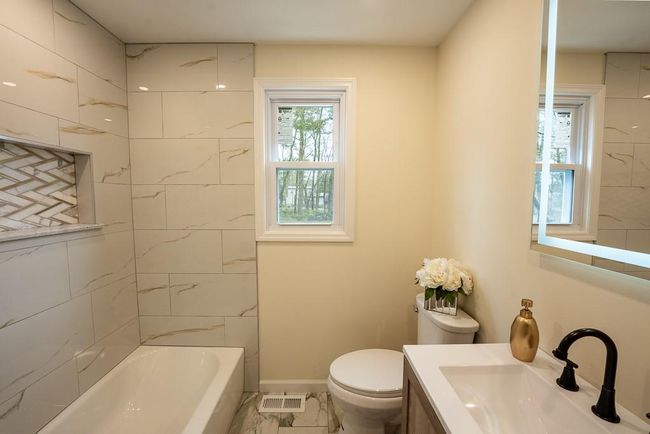 Bathroom featuring vanity, baseboards, shower / washtub combination, toilet, and visible vents | Image 21