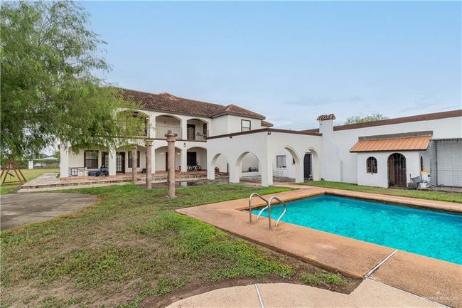 Rear view of house with a patio area, a yard, and a balcony | Image 8