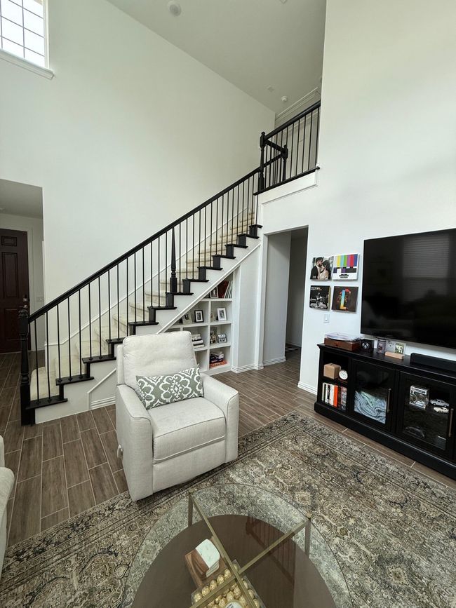 Living area featuring a towering ceiling, stairway, and wood finished floors | Image 19