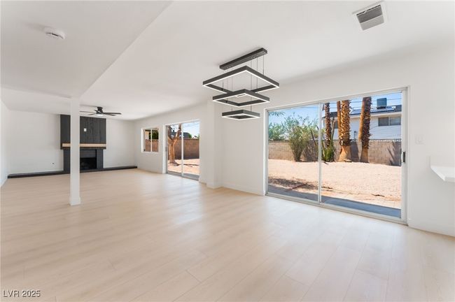 Unfurnished living room featuring a fireplace, wood finished floors, and a ceiling fan | Image 15
