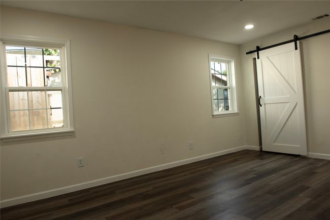 Empty room featuring dark hardwood / wood-style flooring and a barn door | Image 13