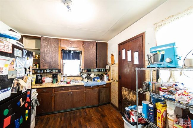 Kitchen with open shelves, freestanding refrigerator, dark wood-style floors, light countertops, and plenty of natural light | Image 11