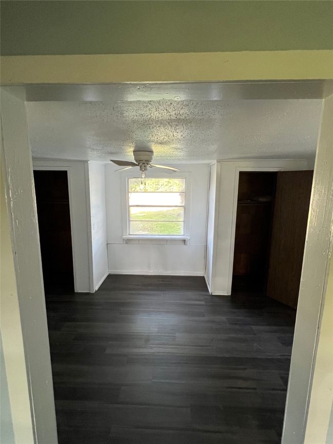 Unfurnished dining area featuring dark wood-style flooring, a textured ceiling, and baseboards | Image 5