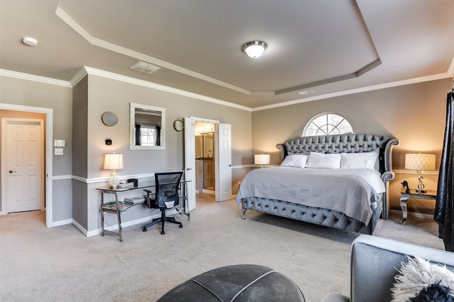Carpeted bedroom featuring ornamental molding, multiple windows, and a tray ceiling | Image 25