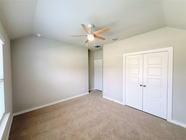 Unfurnished bedroom with lofted ceiling, carpet flooring, a closet, baseboards, and ceiling fan | Image 17