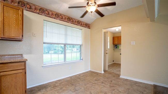 Unfurnished dining area with a ceiling fan and baseboards | Image 9