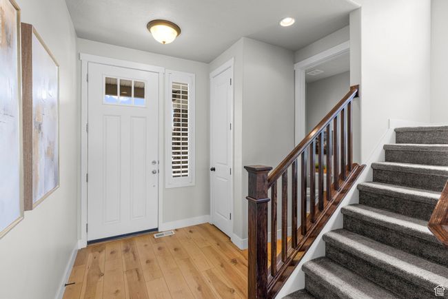 Foyer entrance featuring light wood-style floors, visible vents, baseboards, recessed lighting, and stairs | Image 15